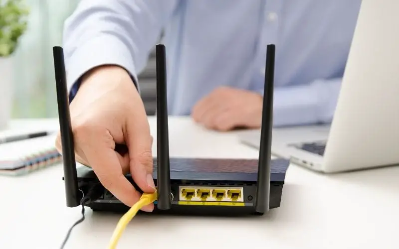 Man plugs ethernet cable into the router