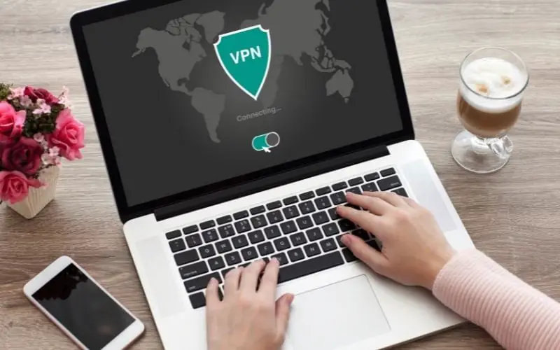 A person accessing the laptop with a VPN on screen